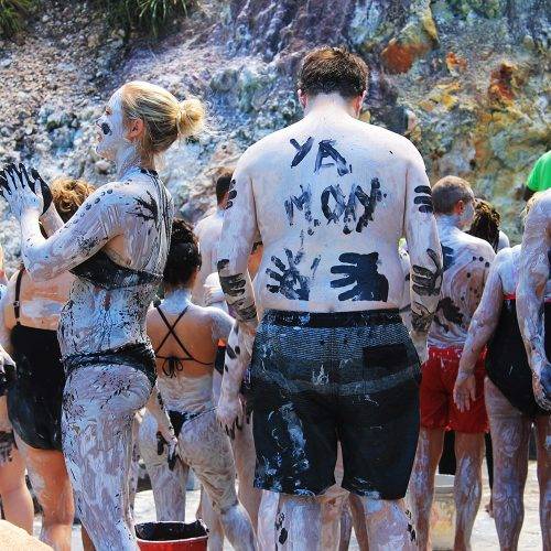 People covered in volcanic mud at Soufriere Hills Volcano mud baths, St. Lucia, West Indies.
